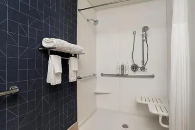 a bathroom with a shower and a toilet and towels at Spark by Hilton West Coxsackie in West Coxsackie