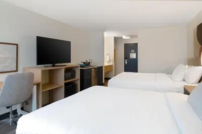 a hotel room with two beds and a flat screen tv at Spark by Hilton West Coxsackie in West Coxsackie