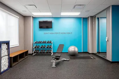 a gym with a blue wall and a chair at Fairfield Inn & Suites by Marriott North Bergen in North Bergen