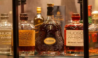 a group of bottles of whiskey on a shelf at The Manhattan Club in New York