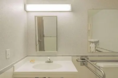 a bathroom with a sink and a large mirror at Days Inn by Wyndham Berlin Meriden in Berlin