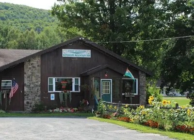 a small building with flowers in front of it at Jimmy OConnor's Windham Mtn Inn in Windham