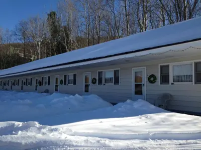 a snow covered house with a pile of snow at Jimmy OConnor's Windham Mtn Inn in Windham
