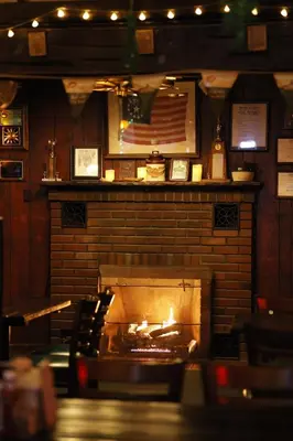 a brick fireplace in a restaurant with an american flag at Jimmy OConnor's Windham Mtn Inn in Windham