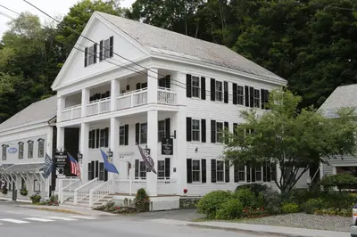 a white building with two flags in front of it at The Vermont House in Wilmington