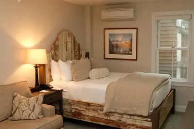 a bedroom with a bed and a chair and a window at The Vermont House in Wilmington