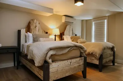 a bedroom with two beds with a wooden headboard at The Vermont House in Wilmington