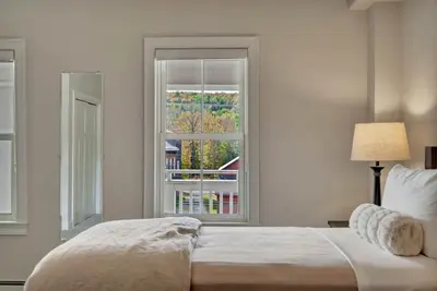a bedroom with a bed and a large window at The Vermont House in Wilmington
