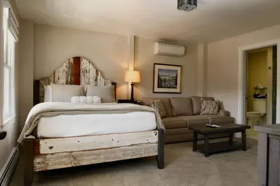 a bedroom with a large bed and a couch at The Vermont House in Wilmington