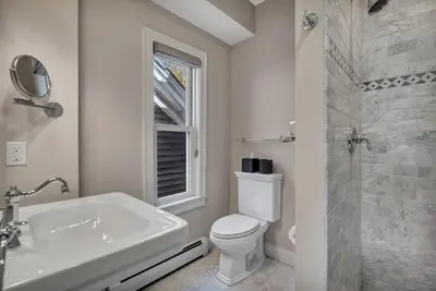 a white bathroom with a toilet and a sink at The Vermont House in Wilmington