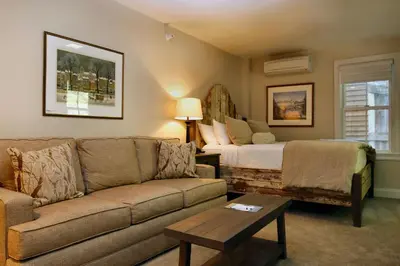a living room with a couch and a bed at The Vermont House in Wilmington