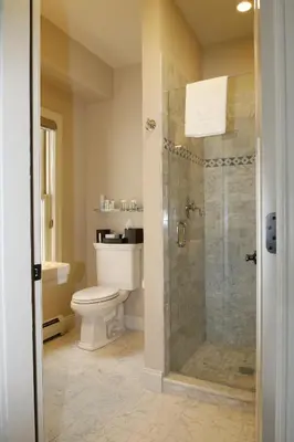 a bathroom with a toilet and a glass shower at The Vermont House in Wilmington