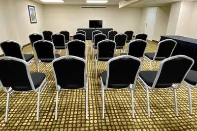 a conference room with chairs and a podium in the middle at Baymont by Wyndham Latham Albany Airport in Latham