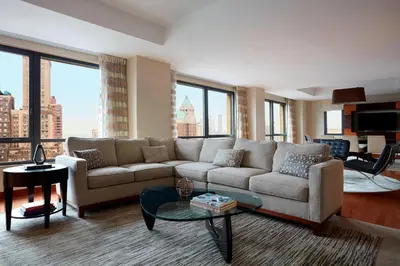 a living room with a couch and large windows at New York Marriott at the Brooklyn Bridge in Brooklyn