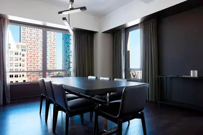 a dining room with a black table and chairs at New York Marriott at the Brooklyn Bridge in Brooklyn