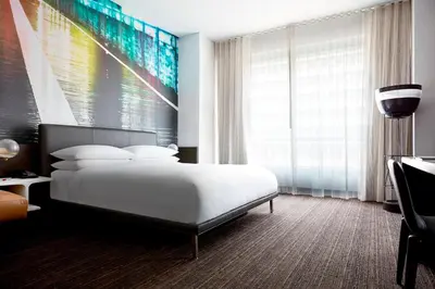 a bedroom with a bed and a large painting on the wall at New York Marriott at the Brooklyn Bridge in Brooklyn