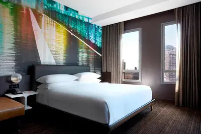 a bedroom with a large white bed and a colorful wall at New York Marriott at the Brooklyn Bridge in Brooklyn