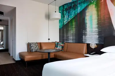a hotel room with a bed and a couch and a table at New York Marriott at the Brooklyn Bridge in Brooklyn