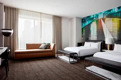 a hotel room with two beds and a couch at New York Marriott at the Brooklyn Bridge in Brooklyn