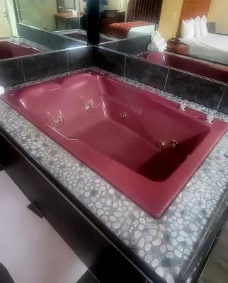 a red bath tub sitting in a bathroom at Jets Motor Inn in Queens