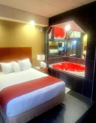 a hotel room with a bed and a bath tub at Jets Motor Inn in Queens