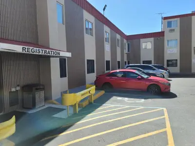 a red car parked in front of a building at Jets Motor Inn in Queens