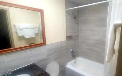 a bathroom with a tub and a toilet and a sink at Jets Motor Inn in Queens