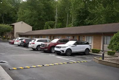 a row of cars parked in a parking lot at Carrier Motor Lodge in Newington