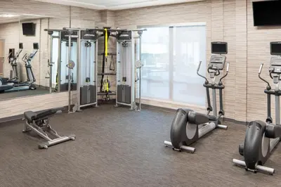 a gym with several tread machines in a room at Courtyard by Marriott Wayne Fairfield in Wayne