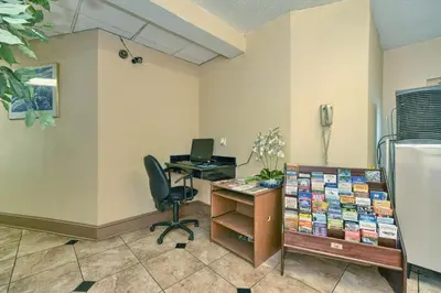 an office with a desk with a computer and a chair at Red Carpet Inn - Stamford in Stamford