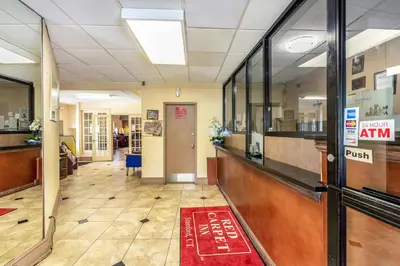 an empty lobby with a red rug on the floor at Red Carpet Inn - Stamford in Stamford