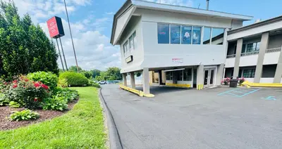 a building with a parking lot in front of it at Red Carpet Inn - Stamford in Stamford