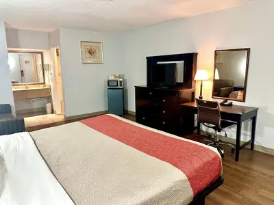 a hotel room with a bed and a desk and a television at Red Carpet Inn Norwalk in Norwalk