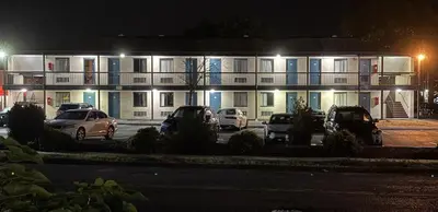 a building with cars parked in front of it at night at Red Carpet Inn Norwalk in Norwalk
