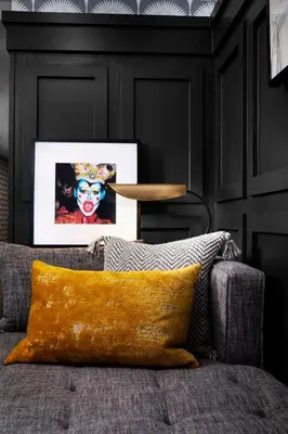 a couch with a yellow pillow in a room with black walls at Redford Hotel in New York