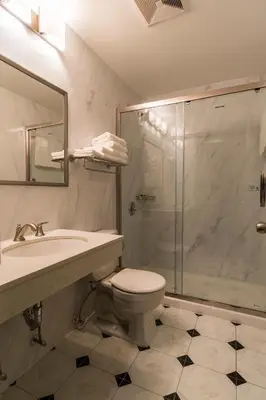 a bathroom with a shower and a toilet and a sink at John Hotel in Queens