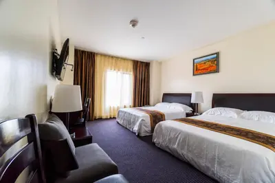 a hotel room with two beds and a window at John Hotel in Queens