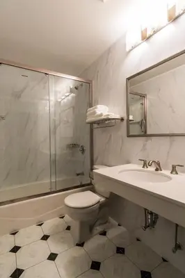 a bathroom with a toilet and a sink and a shower at John Hotel in Queens