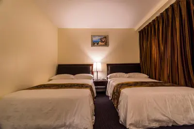 a hotel room with two beds and a window at John Hotel in Queens