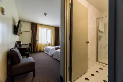 a hotel room with a bed and a bathroom at John Hotel in Queens