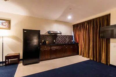 a kitchen with a black refrigerator in a room at John Hotel in Queens