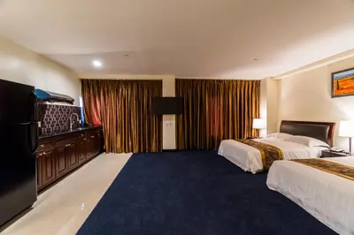 a hotel room with two beds and a flat screen tv at John Hotel in Queens