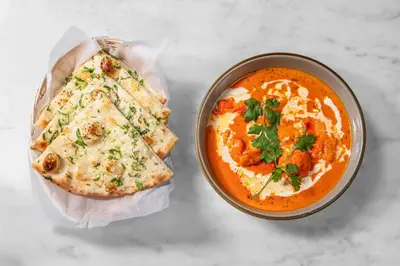 a table with a bowl of soup and a bowl of pizza at Holiday Inn New York City - Wall Street by IHG in New York