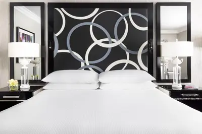 a bedroom with a large white bed with two lamps at The Muse New York in New York