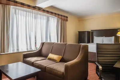 a hotel room with a couch and a bed at Comfort Inn & Suites LaGuardia Airport in Queens