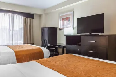 a hotel room with two beds and a flat screen tv at Comfort Inn & Suites LaGuardia Airport in Queens