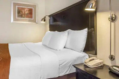 a hotel room with a bed and a telephone at Comfort Inn & Suites LaGuardia Airport in Queens