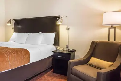 a hotel room with a bed and a chair at Comfort Inn & Suites LaGuardia Airport in Queens