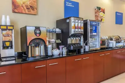 a coffee shop with a counter with coffee machines at Comfort Inn & Suites LaGuardia Airport in Queens
