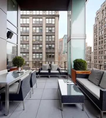 a rooftop patio with tables and chairs on a building at Royalton Park Avenue in New York